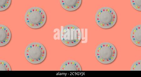 Cappello di paglia con nastro e pompon multicolore. Ripetizione senza giunture. Concetto estivo o di spiaggia. Foto Stock