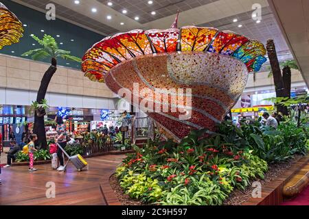 Calici in vetro realizzati con luccicanti e riflettenti lucertole in vetro colorato, Sala partenze transito al Terminal 2, Aeroporto Changi di Singapore, Singapore Foto Stock
