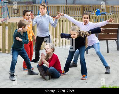 Felici i ragazzi americani che mostra diverse figure durante le fasi di gioco nel parco giochi all'aperto Foto Stock