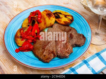 Bistecche di manzo mediamente rare con contorno vegetale di patate al forno e peperone Foto Stock