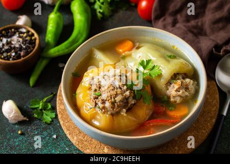Cibo sano. Peperoni paprika farciti con carne e bulgur in brodo con verdure. Foto Stock