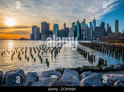 Tramonto lungo l'East River e il porto di New York, tratto dal Brooklyn Bridge Park a DUMBO. New York City; Lower Manhattan; NYC Financial District Foto Stock