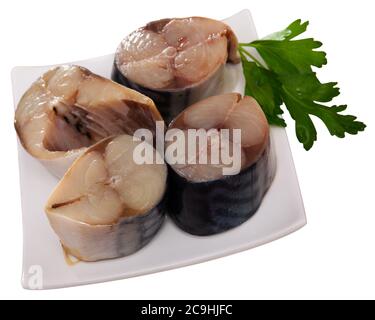 Pezzi di saporito scomber leggermente curato con prezzemolo fresco e baguette croccante sul piatto. Antipasto di pesce. Isolato su sfondo bianco Foto Stock