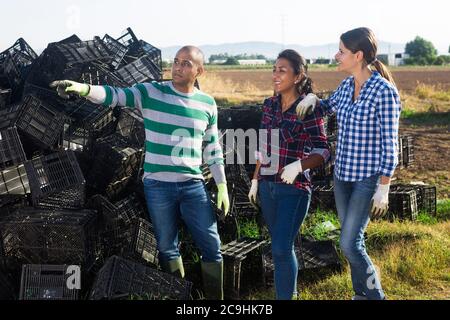 Latina e caucasici che comunicano vicino a scatole vuote in azienda durante il tempo di raccolta Foto Stock