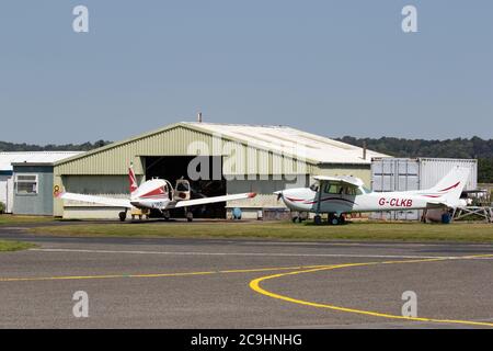 Aeromobili leggeri parcheggiati all'esterno dell'appendiabiti. Aeroporto di Wolverhampton Halfpenny Green. Bobbington. Staffordshire. REGNO UNITO Foto Stock