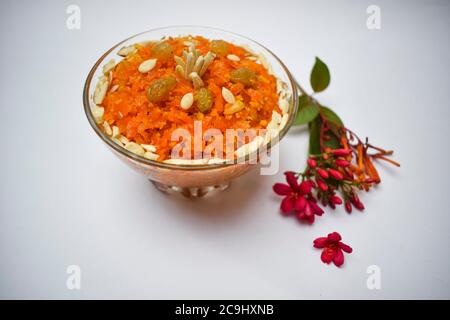 Vista dall'alto del pudding di carota conosciuto come Gajar ka halwa un piatto dolce popolare dall'India, Pakistan mangiato durante i festival, isolato su sfondo bianco con Foto Stock