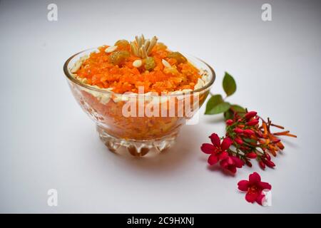 Vista laterale del budino di carota conosciuto come Gajar ka halwa un piatto dolce popolare dall'India, Pakistan mangiato durante i festival, isolato su bianco fondo WIT Foto Stock