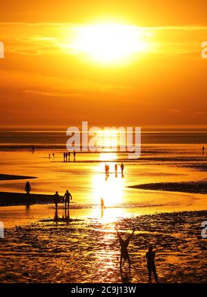 Heacham, Regno Unito. 30 luglio 2020. Dopo una giornata molto calda, la gente aspetta il tramonto mentre lascia una calda luce arancione sulla spiaggia di Heacham, Norfolk. Credit: Paul Marriott/Alamy Live News Foto Stock