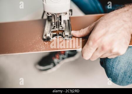 Tecnologia di pavimentazione flottante per pannelli laminati - rifilatura e assemblaggio dei pannelli in modo rapido e semplice - pavimenti a prezzi accessibili Foto Stock