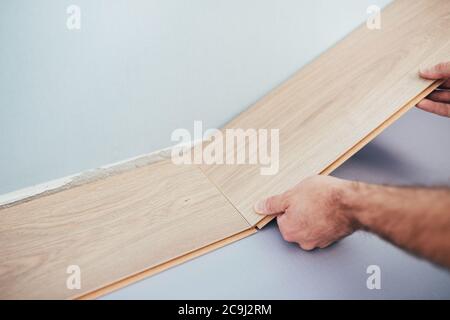 Il master laminato collega i pannelli in un unico intero - faccia-esso-te pavimento - veloce ed economico pavimento nella casa Foto Stock