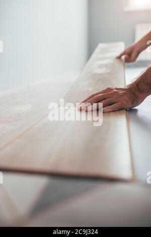 Tecnologia di pavimentazione flottante per pannelli laminati - rifilatura e assemblaggio dei pannelli in modo rapido e semplice - pavimenti a prezzi accessibili Foto Stock