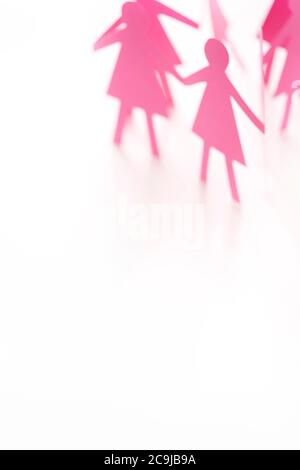 Figure femminili della catena di carta con taglio rosa su sfondo bianco. Foto Stock