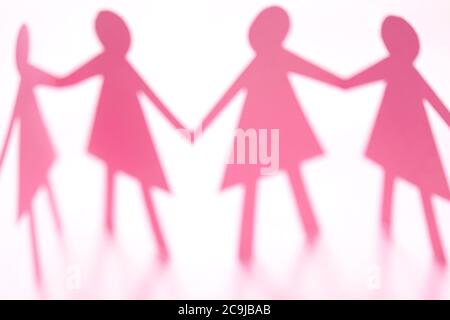 Figure femminili della catena di carta con taglio rosa su sfondo bianco. Foto Stock