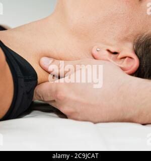Chiropractor che esamina il collo del paziente. Foto Stock