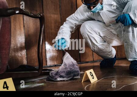 Scena del crimine. Esperto forense che raccoglie prove da una scena criminale. Foto Stock