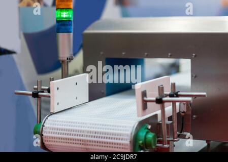 Macchina per il rilevamento di metalli - utilizzata per il controllo della qualità negli alimenti o in altri prodotti. L'allarme viene generato se il sistema rileva un prodotto difettoso o contaminato Foto Stock
