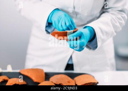 Archeologi che ricostruiscono le ceramiche rotte in laboratorio. Foto Stock