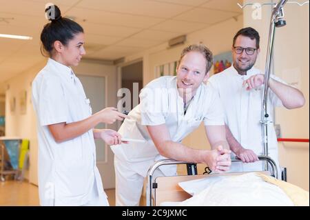 Tre infermieri in un corridoio ospedaliero. Foto Stock