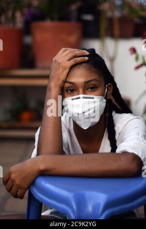 Giovane donna che indossa una maschera a Bogotà, Colombia, durante lo scoppio del 2019-20 del nuovo coronavirus SARS-COV-2. SARS-COV-2 causa un i respiratorio Foto Stock