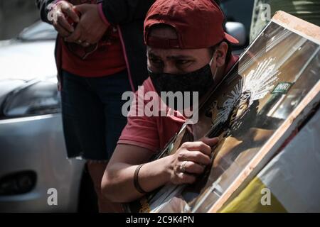 Managua, Nicaragua. 31 luglio 2020. Un credente cattolico che indossa una maschera facciale conserva un'immagine di Gesù dopo che un uomo ha gettato una bottiglia bruciante contro la cattedrale. Secondo i media locali, si dice che negli ultimi giorni siano stati compiuti attacchi contro altre due chiese. Le chiese cattoliche hanno offerto rifugio agli studenti e ai membri dell'opposizione durante le proteste contro il governo del capo di stato Ortega nel 2018. Credit: Carlos Herrera/dpa/Alamy Live News Foto Stock