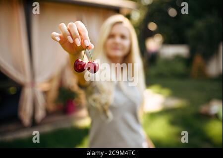 Tavolo, tè partito, donna mostra ciliegie Foto Stock