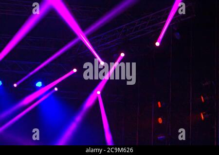 Raggi di luce viola e blu sul palco al buio Foto Stock