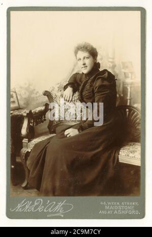 Tessera vittoriana raffigurante uno studio con oggetti di scena, di una bella giovane donna vittoriana in abito alla moda con spalla di maniche di montone, datata luglio 1899, Maidstone, Kent, Inghilterra, REGNO UNITO Foto Stock