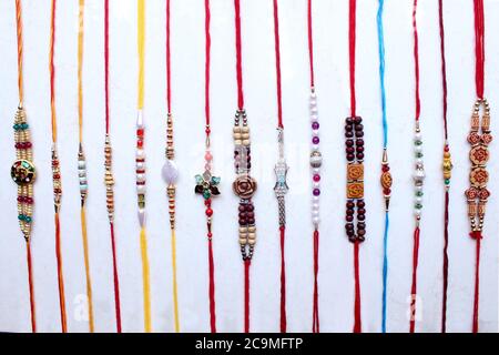 Rakhi colorato, collezione di braccialetti per il festival indiano Raksha Bandhan su sfondo bianco Foto Stock