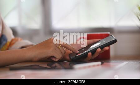 Una donna sta tenendo un telefono cellulare con una chiamata in arrivo da un chiamante sconosciuto. Foto Stock