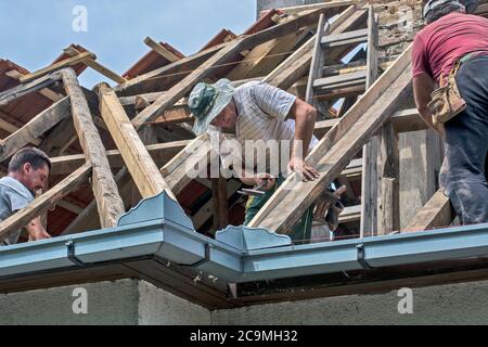 Zrenjanin, Serbia, 22 luglio 2020. Un gruppo di maestri sta lavorando sul tetto di una casa privata per sostituire una vecchia piastrella. Usano una bella giornata e stabile Foto Stock