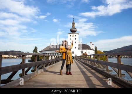 le ragazze felici vanno oltre il ponte per l'ort castello, austria. viaggio di famiglia Foto Stock