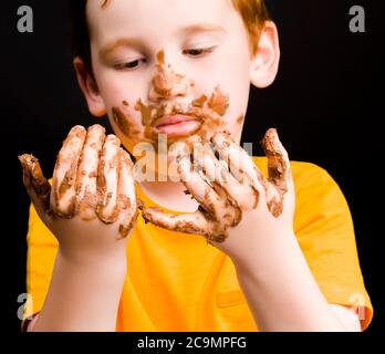 vero cioccolato al latte e un bambino che viene completamente cosparso di cioccolato al latte fuso Foto Stock