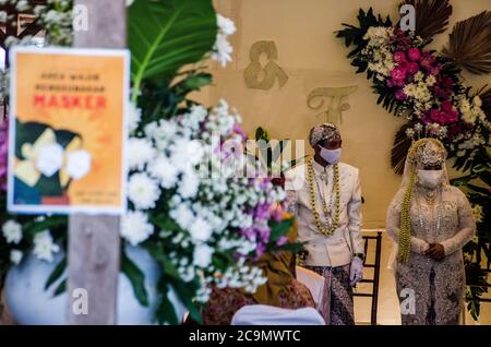 Indonesia. 01 agosto 2020. Una coppia appena sposata che indossa maschere facciali in mezzo al coronavirus COVID-19 mostra il loro certificato di matrimonio durante la cerimonia nuziale a Ngamprah, Giava Occidentale, Indonesia il 1 agosto 2020. Il governo indonesiano permette ai suoi cittadini di sposarsi in mezzo a una pandemia di coronavirus, ma deve continuare ad attuare protocolli sanitari come indossare maschere. (Foto di Bukbisj Candra Ismeth Bey/Sipa USA) Credit: Sipa USA/Alamy Live News Foto Stock