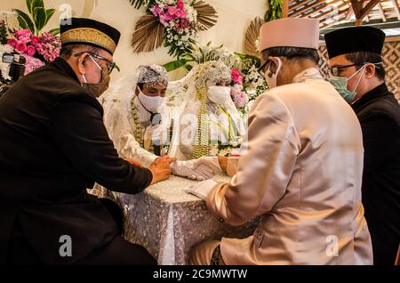 Indonesia. 01 agosto 2020. Una coppia appena sposata che indossa maschere facciali in mezzo al coronavirus COVID-19 mostra il loro certificato di matrimonio durante la cerimonia nuziale a Ngamprah, Giava Occidentale, Indonesia il 1 agosto 2020. Il governo indonesiano permette ai suoi cittadini di sposarsi in mezzo a una pandemia di coronavirus, ma deve continuare ad attuare protocolli sanitari come indossare maschere. (Foto di Bukbisj Candra Ismeth Bey/Sipa USA) Credit: Sipa USA/Alamy Live News Foto Stock
