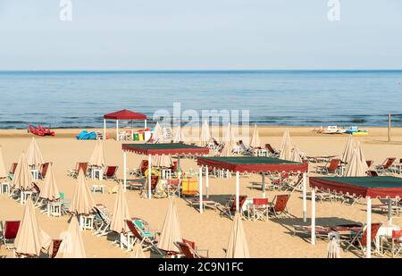 Vista sulla spiaggia di Marina di Pietrasanta con sabbia bianca, ombrelloni e sedie al mattino presto in Versilia, Toscana, Italia Foto Stock