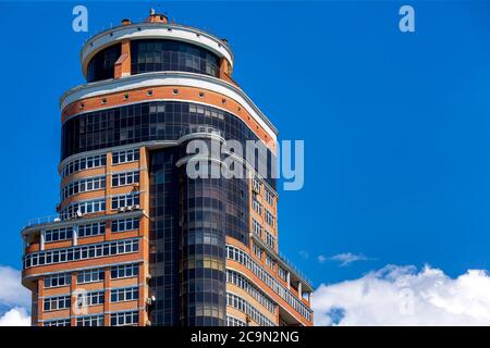 Facciata dell'edificio a più piani sullo sfondo del cielo, la casa monolitica con ripieno di mattoni. Foto Stock