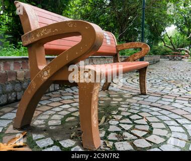 Un vuoto di una panchina nel parco. Foto Stock