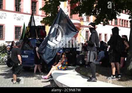 Erfurt, Germania. 01 agosto 2020. Partecipanti ad una manifestazione con lo slogan 'organizzare l'antifascista auto-protezione' stand con bandiere di fronte alla cancelleria di Stato. Il contesto degli eventi è un incidente nella notte dal 17. Al 18. Luglio. A quel tempo un gruppo di giovani è stato fisicamente aggredito e ferito davanti alla Cancelleria di Stato di Erfurt. Secondo le autorità investigative, alcuni aggressori hanno un background estremista di destra. Credit: Bodo Schackow/dpa-Zentralbild/dpa/Alamy Live News Foto Stock