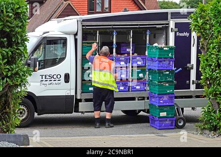 Supermarket online internet supply chain home food drogheria shopping delivery on Tesco van driver carica sul carrello presso la sede del cliente Essex England UK Foto Stock