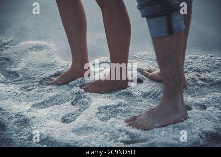 Primo piano ritratto di piedi, gambe di coppia in piedi vicino al lago solt in solt Foto Stock