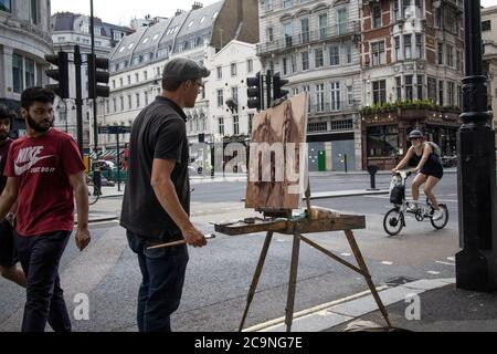 Artista di strada che cattura su tela l'angolo di Wellington Street e Stran, Londra centrale, Inghilterra, Regno Unito Foto Stock
