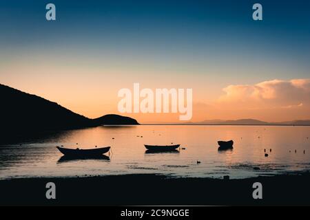 Bellissimo paesaggio con la silhouette di barche e moutains durante il tramonto nel lato nord dell'Isla del Sol, Bolivia Foto Stock