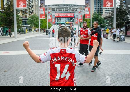 Londra, Regno Unito. 1 agosto 2020. Un giovane Arsenale che indossa una camicia a sostegno del capitano dell'Arsenale Pierre-Emerick Aubameyang si acclama nella squadra fuori dallo stadio di Wembley poco prima della finale della fa Cup tra Arsenal e Chelsea. Normalmente in maggio, la competizione ha dovuto essere riprogrammata a causa della pandemia del coronavirus. Non saranno ammessi spettatori o fan nello stadio, sarà la prima 'Fanless fa Cup Final'. Credit: Stephen Chung / Alamy Live News Foto Stock