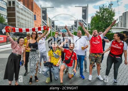 Londra, Regno Unito. 1 agosto 2020. Alcuni tifosi dell'Arsenal incoraggiano la loro squadra in Olympic Way fuori dallo stadio di Wembley poco prima della finale della Coppa fa tra Arsenal e Chelsea. Normalmente in maggio, la competizione ha dovuto essere riprogrammata a causa della pandemia del coronavirus. Non saranno ammessi spettatori o fan nello stadio, sarà la prima 'Fanless fa Cup Final'. Credit: Stephen Chung / Alamy Live News Foto Stock