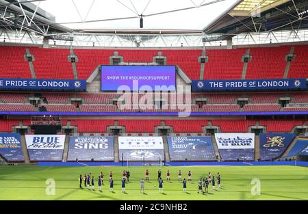 I giocatori e i funzionari delle partite si levano in piedi intorno al cerchio centrale per riconoscere la campagna Heads Up al Wembley Stadium, Londra. Foto Stock