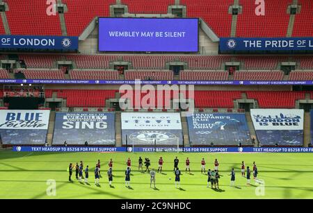 I giocatori e i funzionari delle partite si levano in piedi intorno al cerchio centrale per riconoscere la campagna Heads Up al Wembley Stadium, Londra. Foto Stock