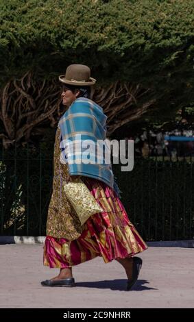 COPACABANA, BOLIVIA - 24 LUGLIO 2016: Unidentified bolivian donna che indossa abiti tradizionali cammina intorno alla piazza a Copacabana, Bolivia Foto Stock