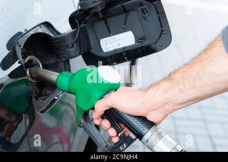 Il rifornimento di carburante della macchina in corrispondenza di una stazione di rifornimento della pompa del combustibile. Man mano driver di riempimento e di pompaggio olio di benzina la vettura con il carburante alla stazione di rifornimento. Il rifornimento di carburante per auto Foto Stock