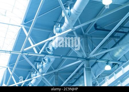 Luci blu e sistema di ventilazione in linea lunga sul soffitto dell'edificio industriale. Sala espositiva. Costruzione di fabbrica di soffitto Foto Stock