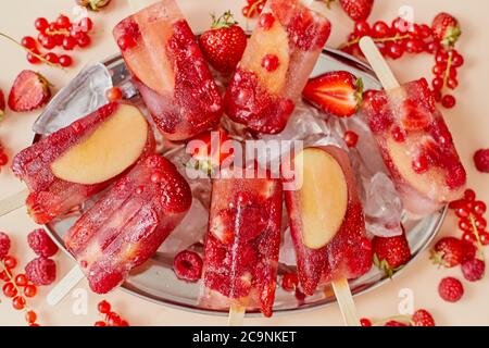 Fragola mela lampone e gelato al ribes rosso in vassoio metallico con cubetti di ghiaccio Foto Stock